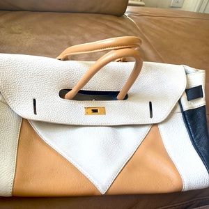 A cream colored beautiful large bag great for travel